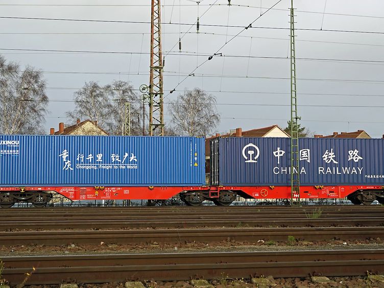 Two Chinese container railway wagons on the rails.