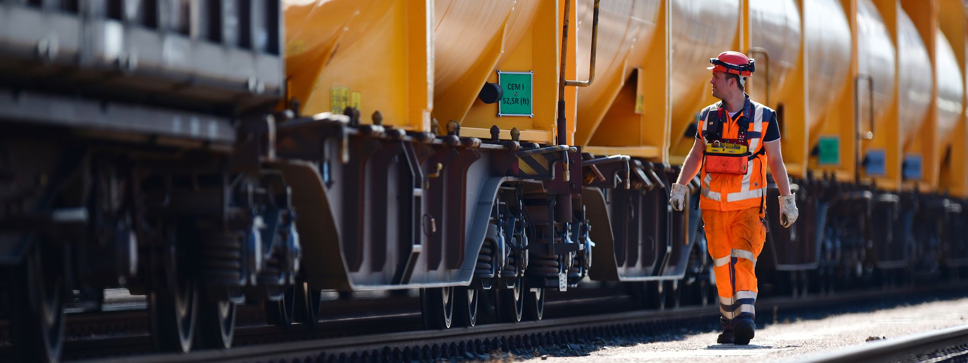 A DB Cargo employee walks alongside a tank car train