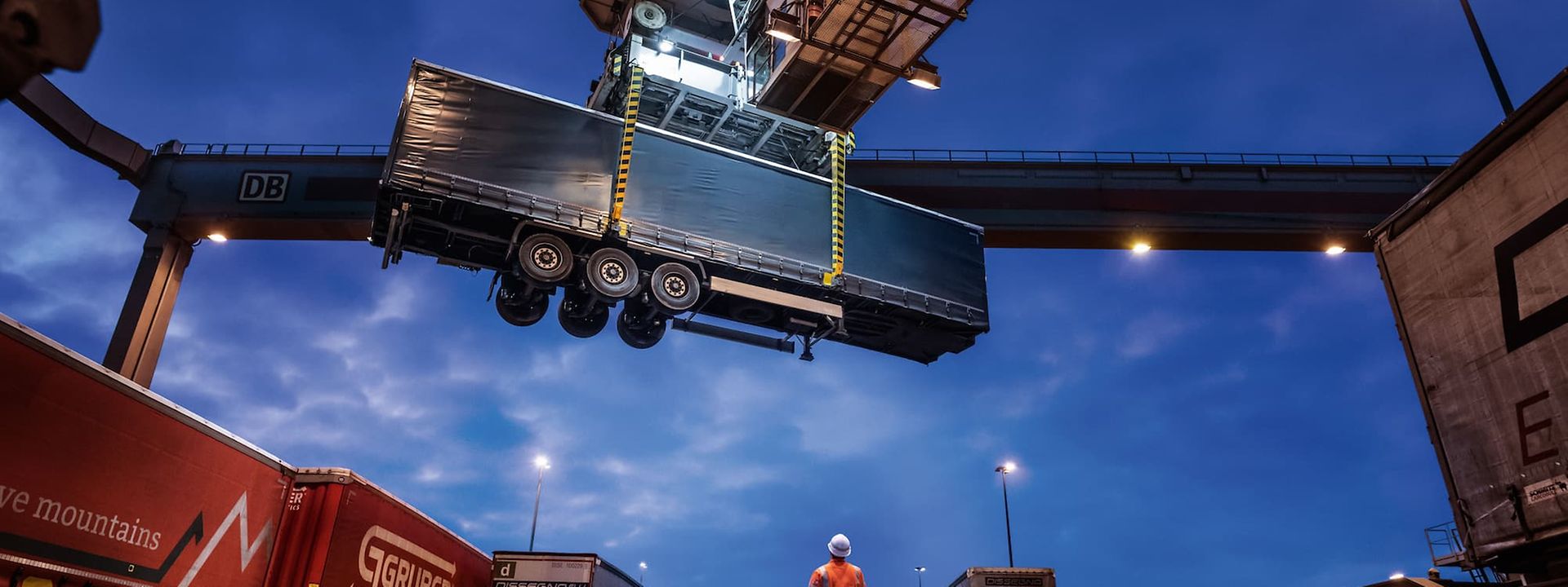 A trailer is craned at night