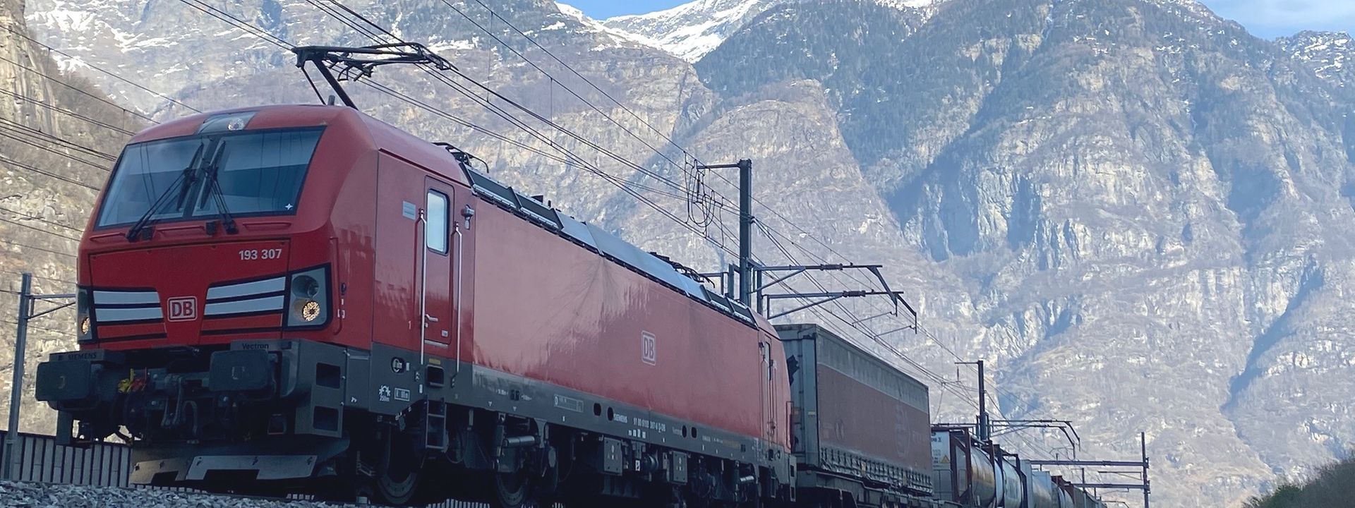 Güterzug mit Bergen im Hintergrund - Südportal Pollegio